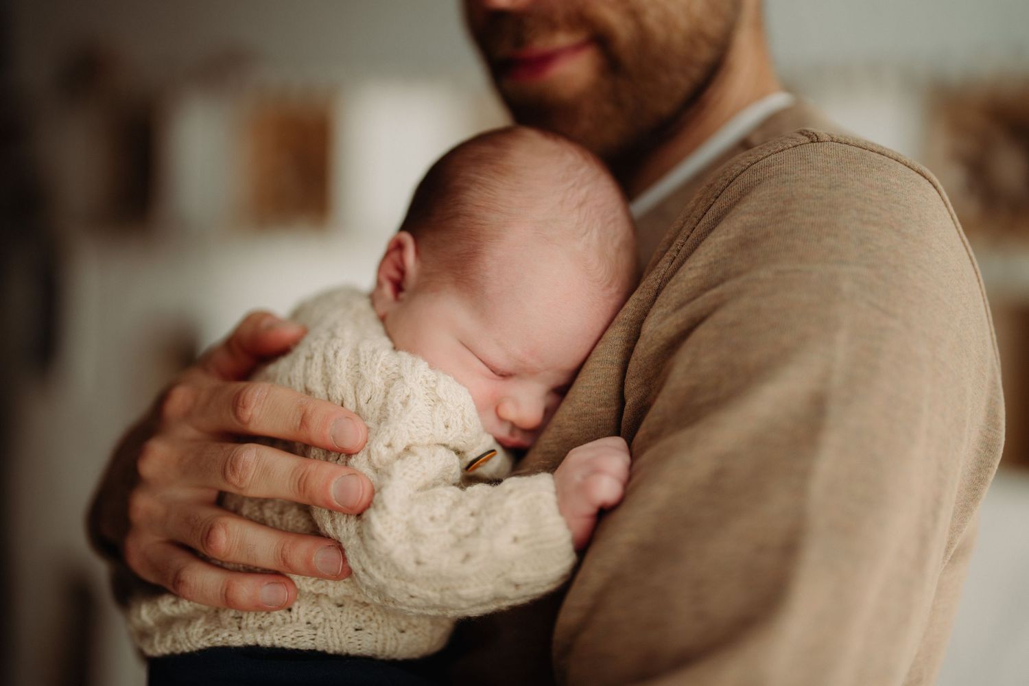 Vater hält sein schlafendes Baby an der Brust