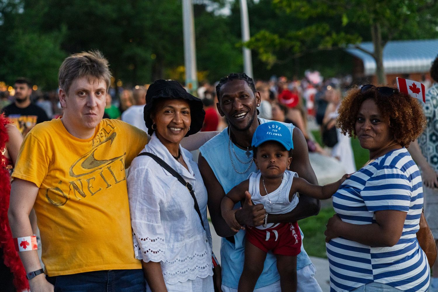 Crowd of people gathered outdoors wearing colorful shirts at public event.