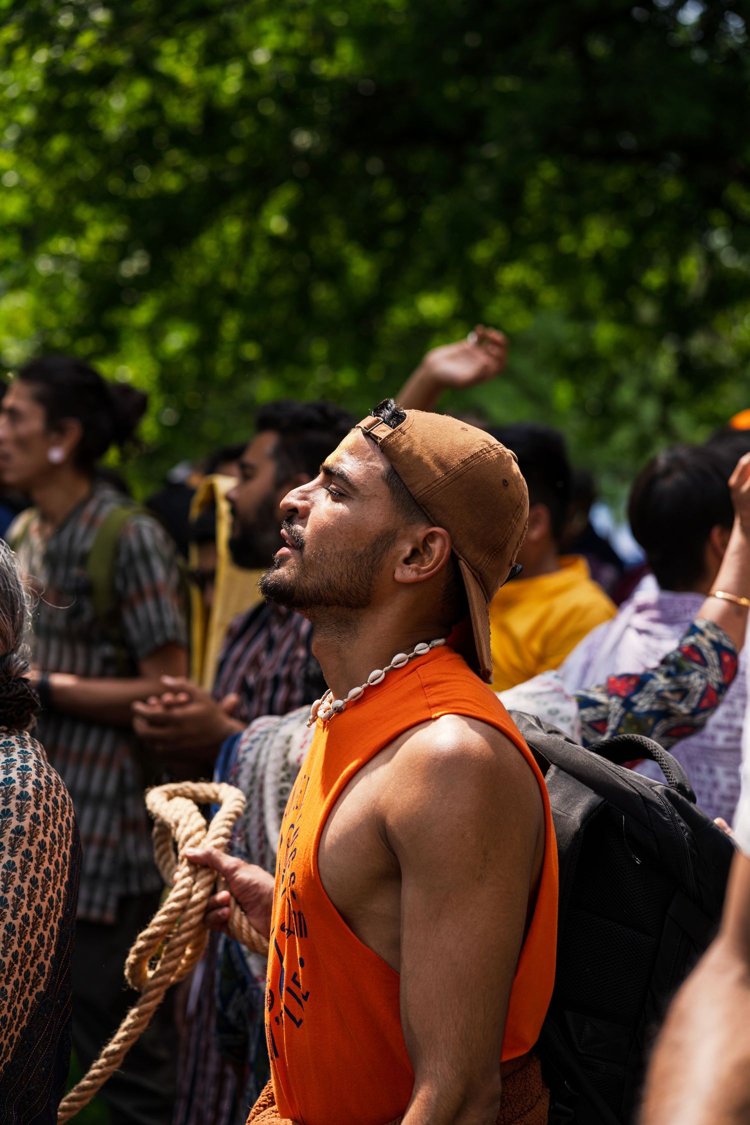 Crowd enjoying an outdoor event with people in orange shirts reacting enthusiastically.