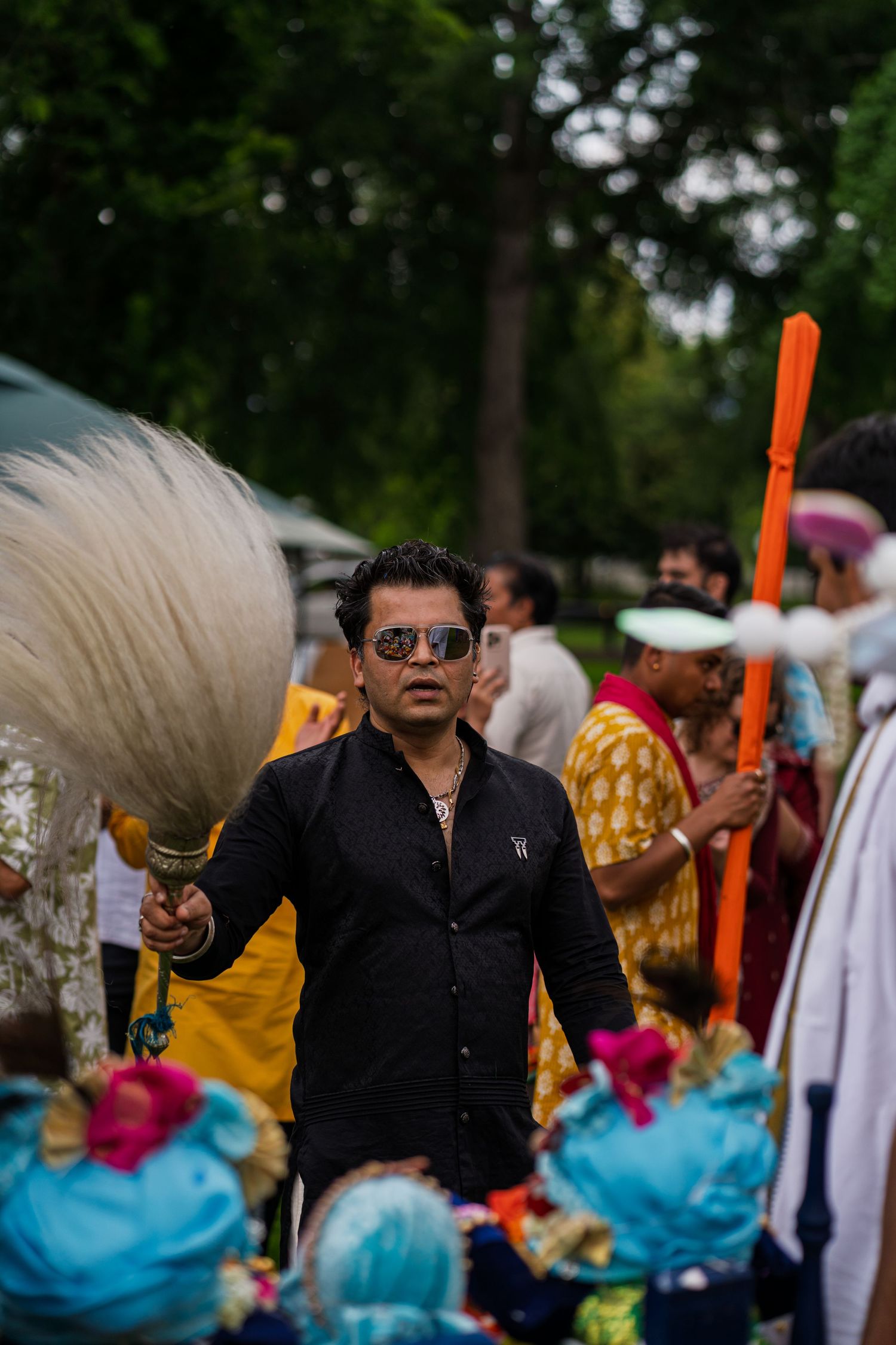Colorful festival scene with performers in black attire and bright traditional costumes.