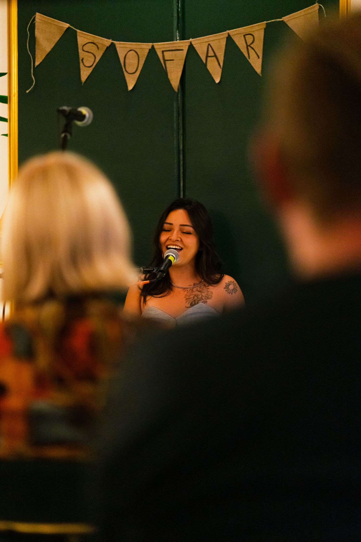 Live music performance in a cozy venue with decorative triangle banners hanging overhead.