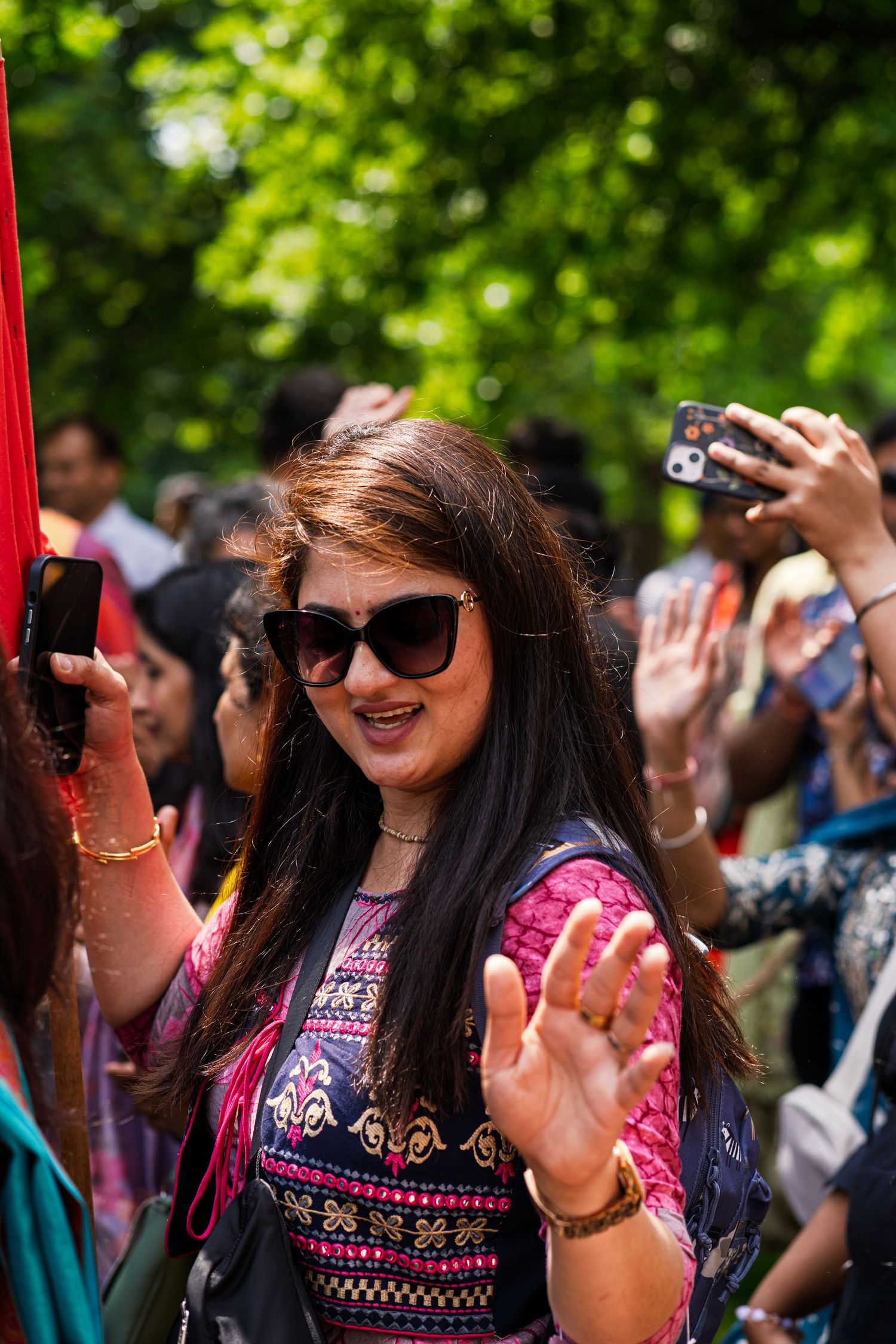 Festival attendees in colorful clothing taking photos and enjoying the celebration.