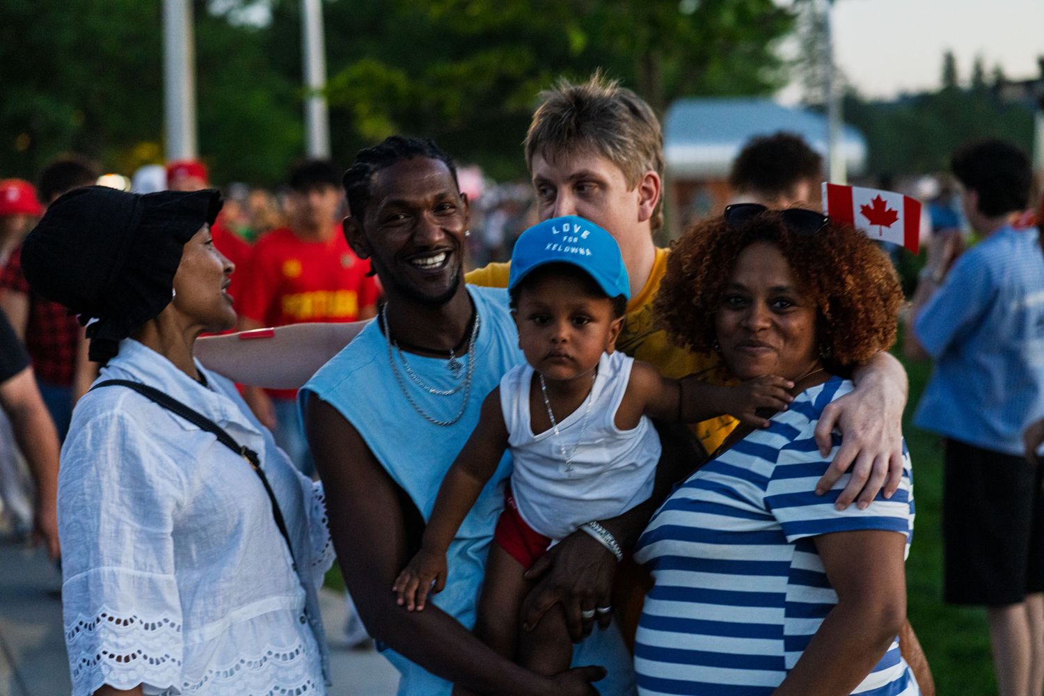 Diverse group of people gathering at an outdoor community event during sunset.