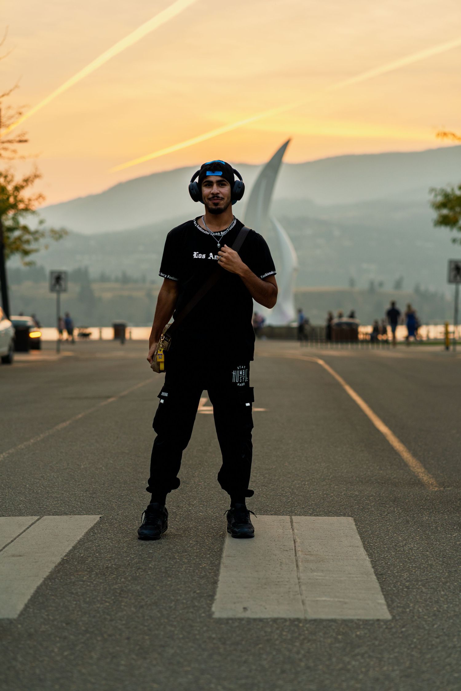 Dancer performs street moves against a golden sunset sky and mountain silhouette.