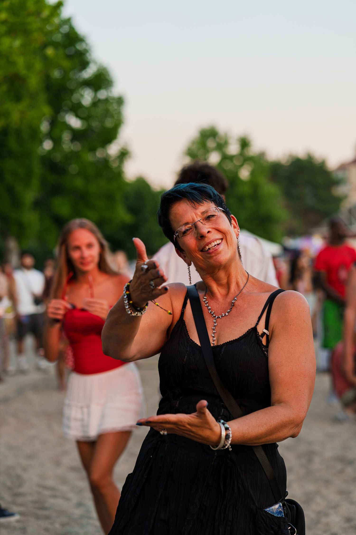 People enjoying themselves at outdoor beach or waterfront gathering at sunset.