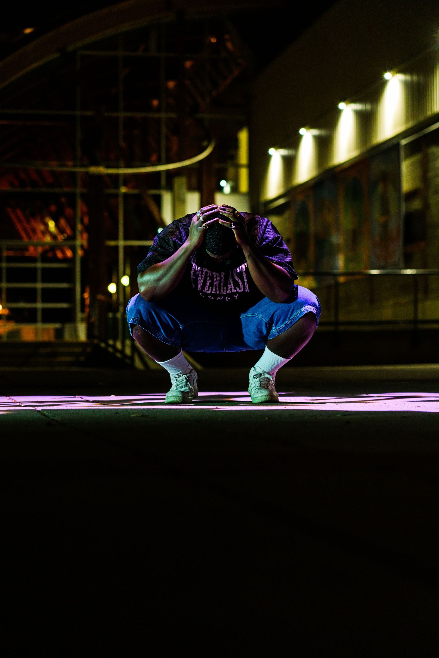 Colorful sneakers illuminated by dramatic lighting against a dark background create an artistic nighttime display.