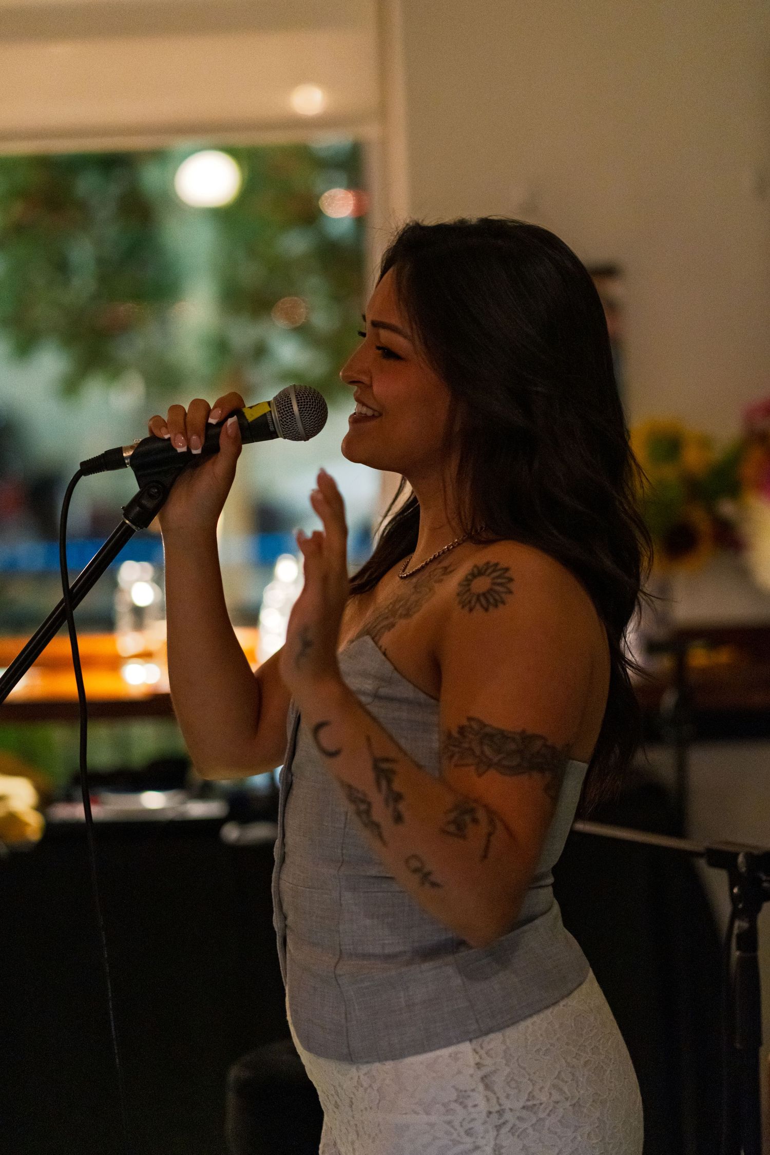 Singer performing passionately with microphone in atmospheric evening venue lighting.
