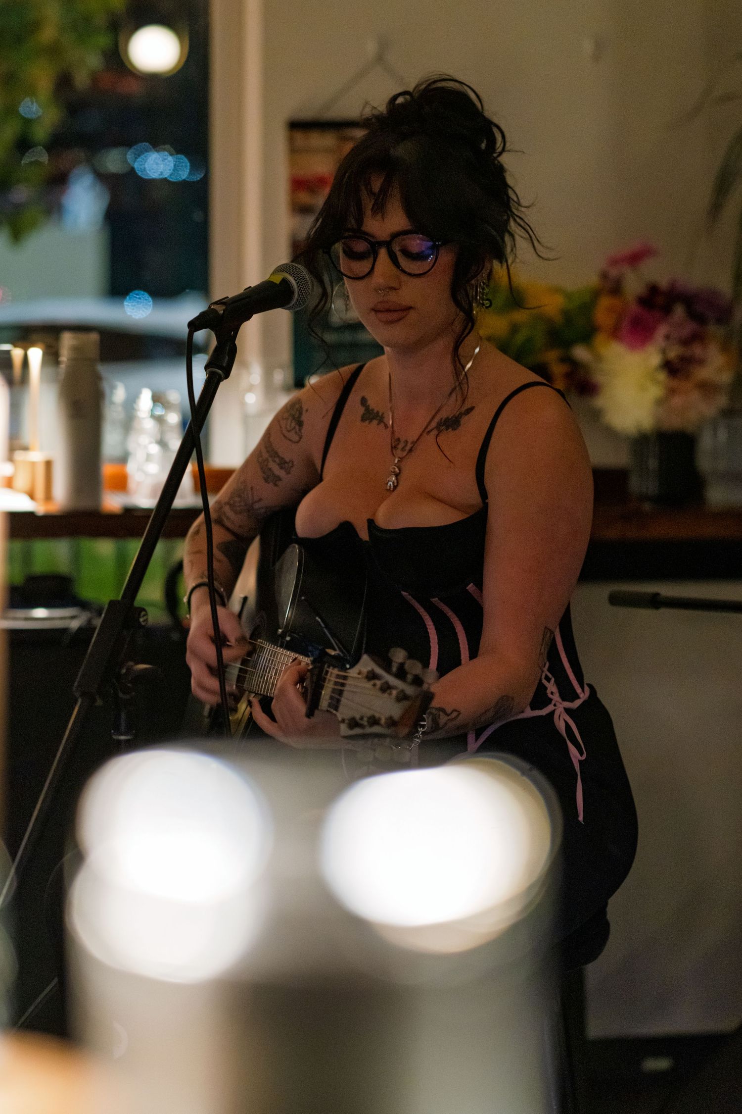 Musicians perform on stage in dim lighting with spotlights creating ambient atmosphere.