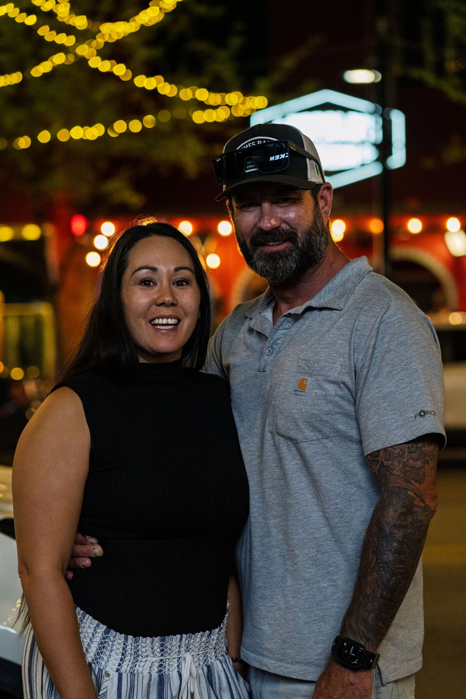 Couple enjoying a night out under festive string lights.