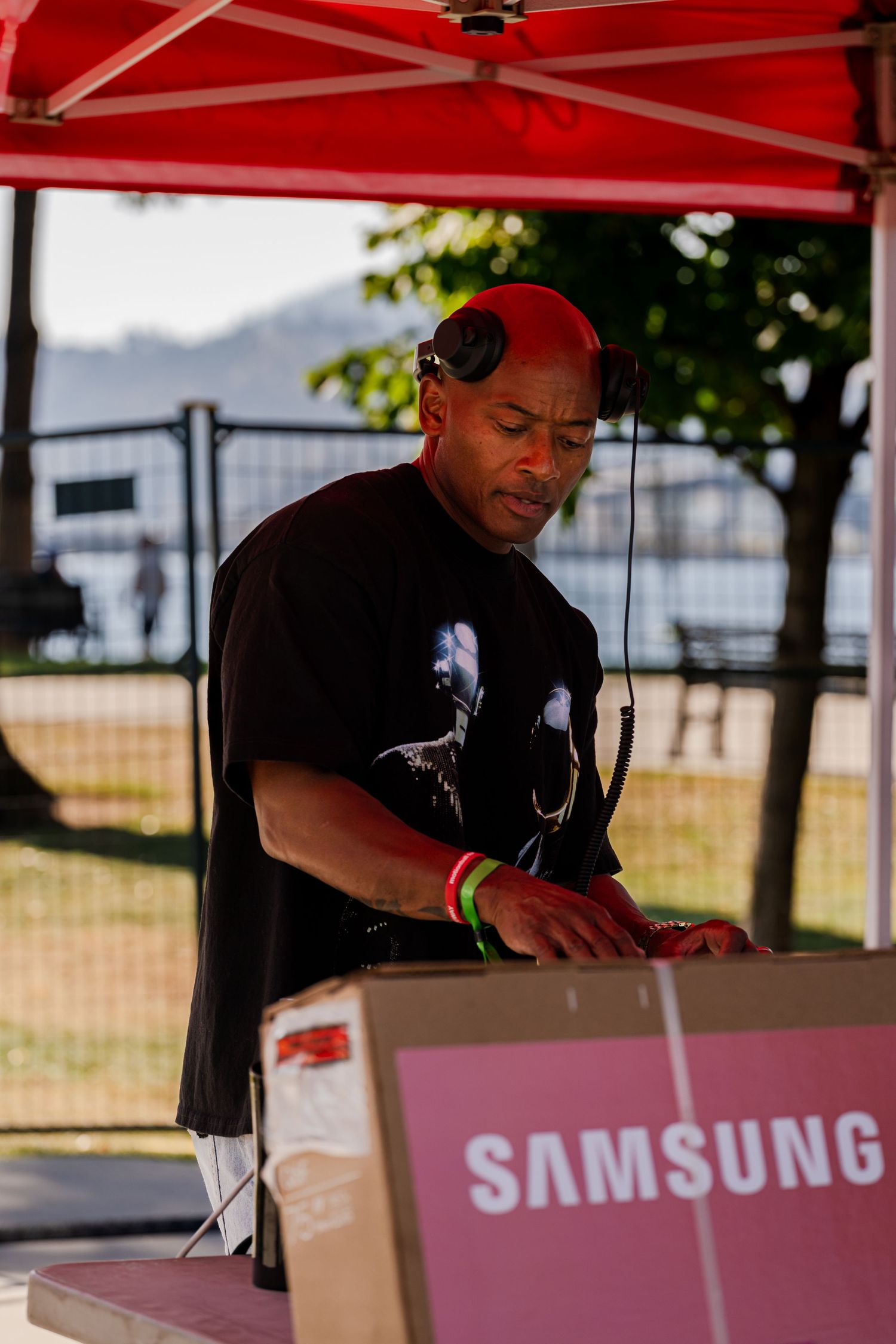 Event staff working under a red Samsung branded tent at an outdoor festival.