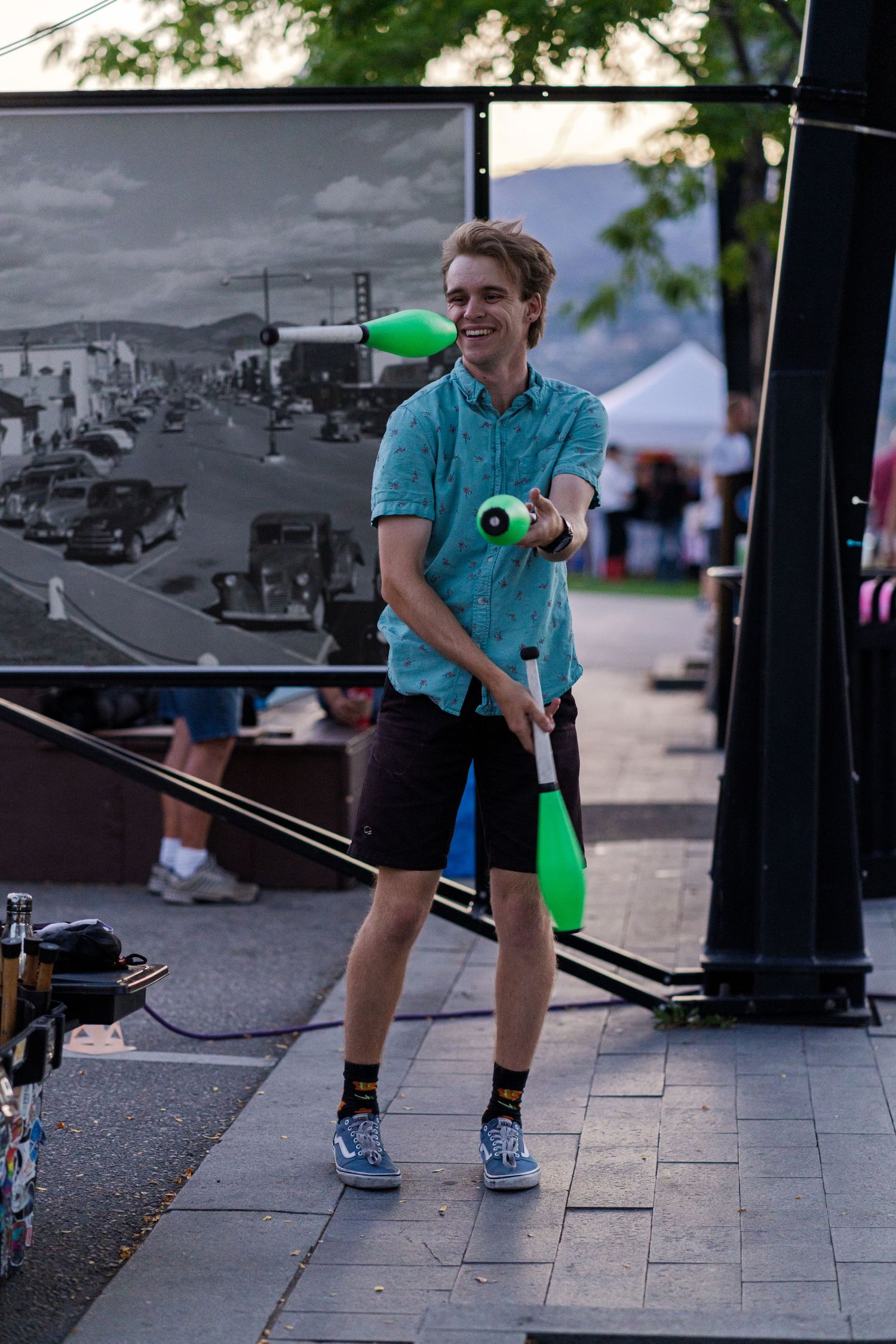 Person demonstrating kendama ball and string toy tricks on a paved outdoor area.