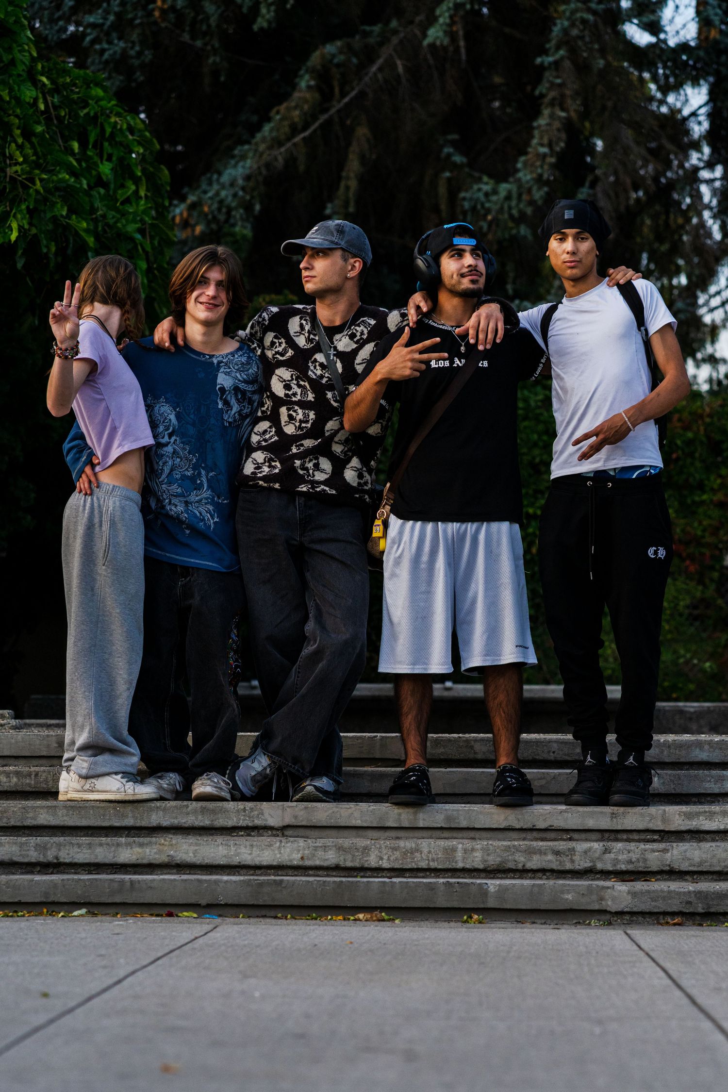 Group of people sitting casually on concrete steps outdoors on a sunny day.