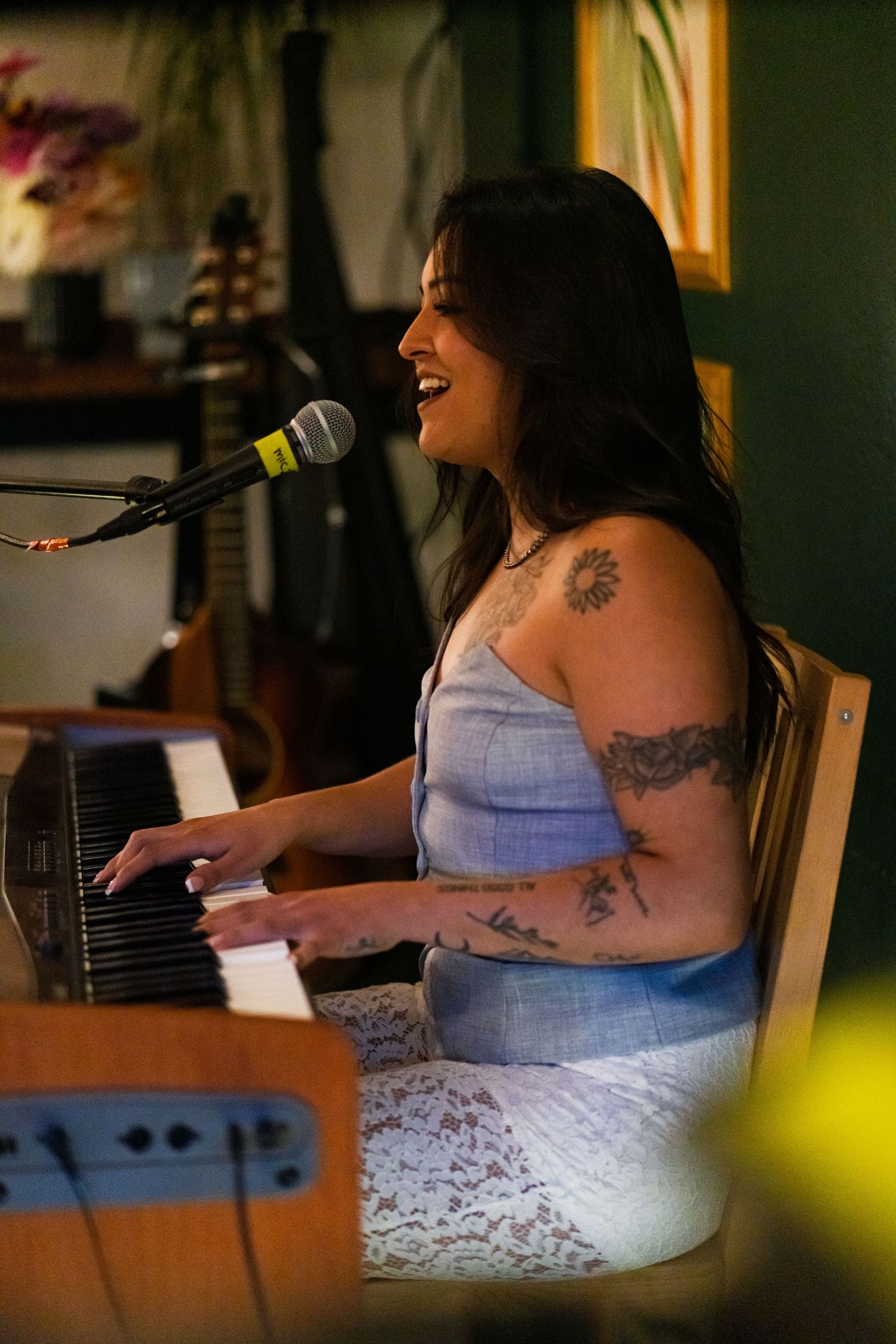 Musician playing keyboard and singing during an intimate performance.