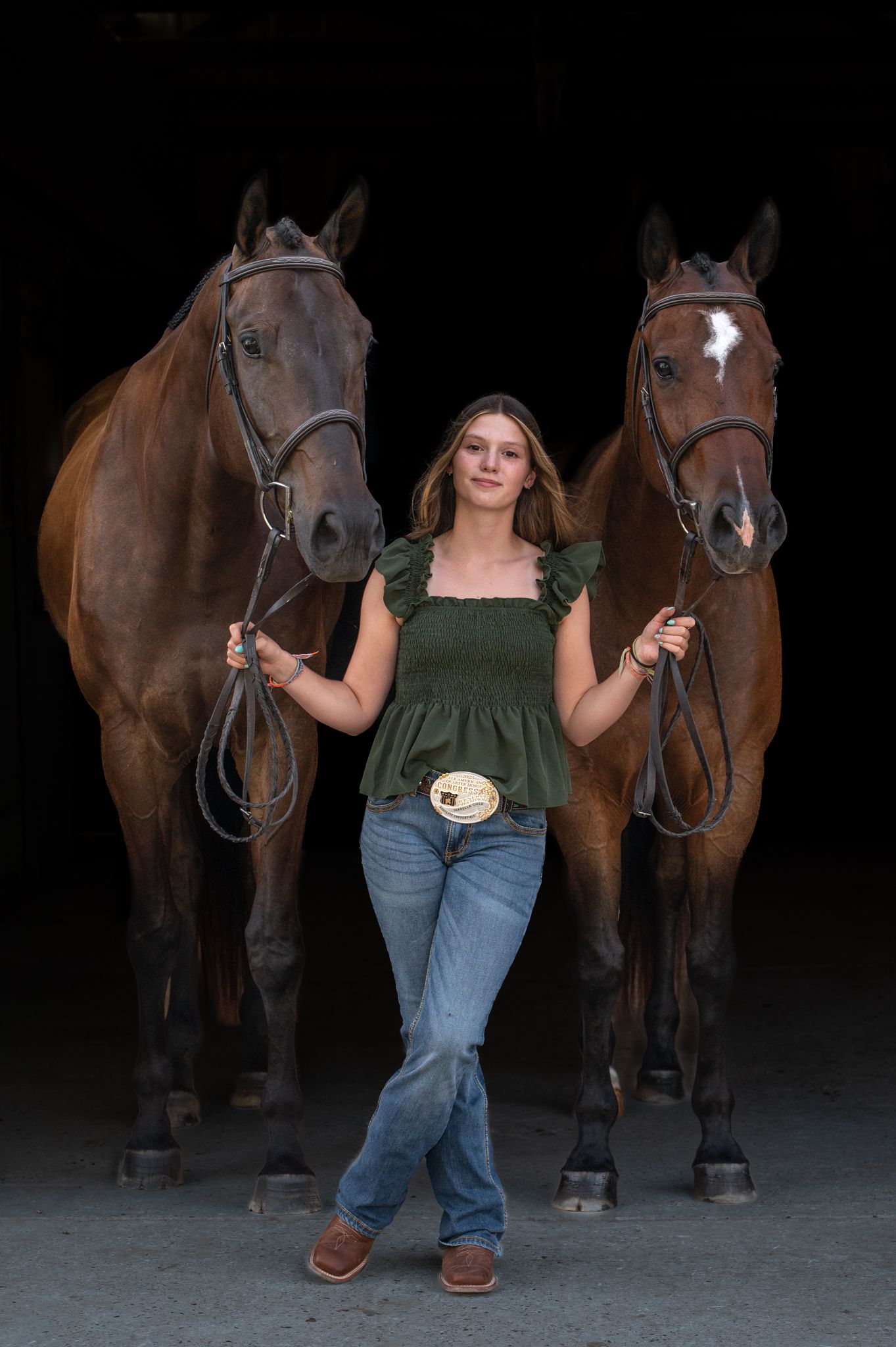 A person in casual attire stands with two brown horses in a dark indoor setting, creating a series of similar poses.