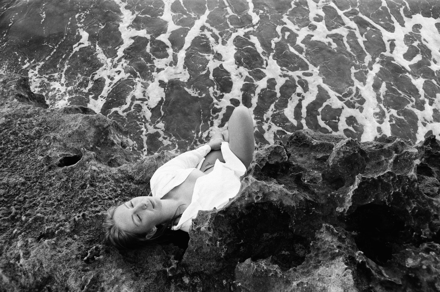 Emotive portrait of a woman embracing stillness on the rocks — shot on film at Mettam’s Pool, Western Australia.