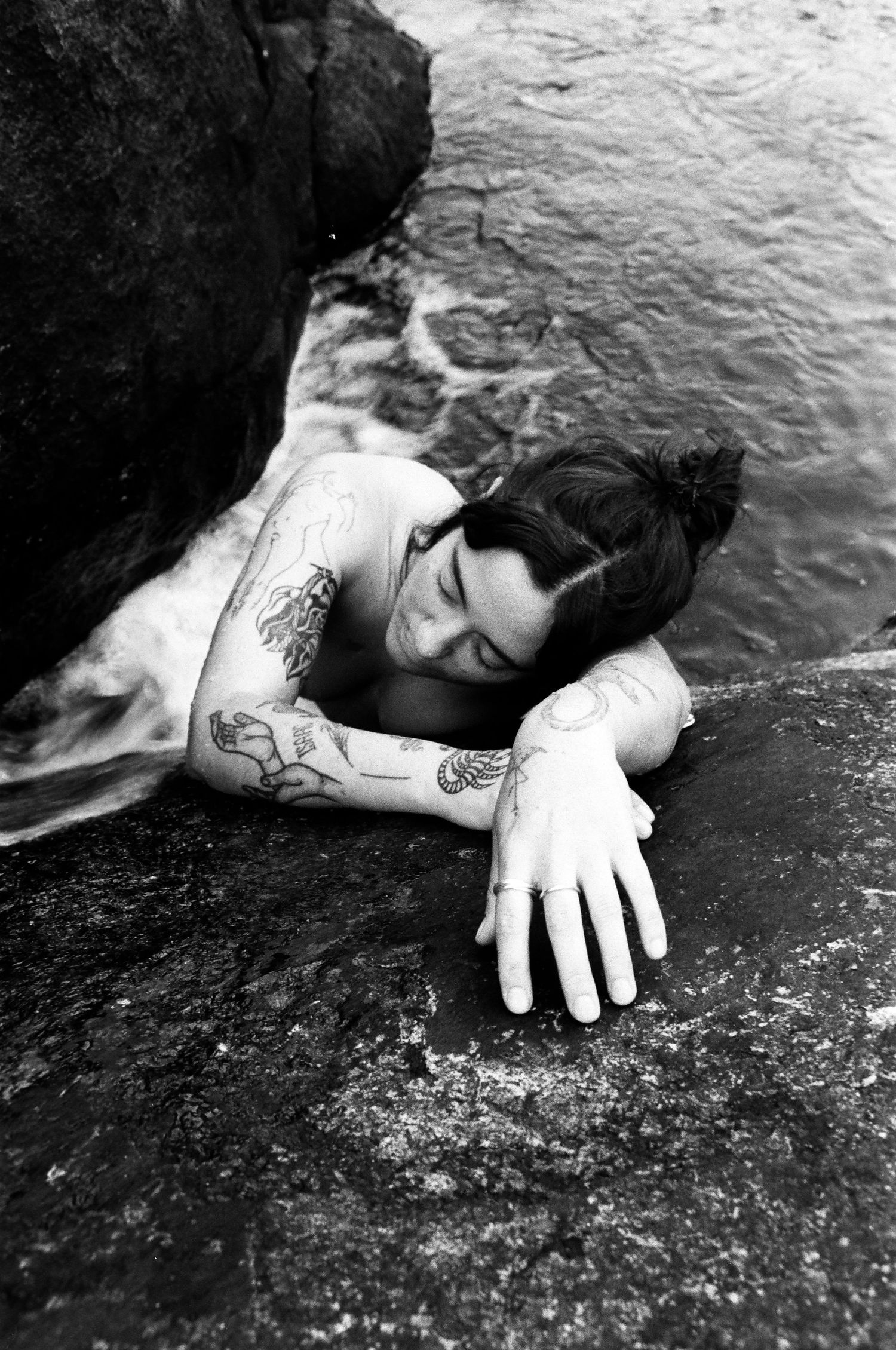 Close portrait at the waterline, reflections in a rocky basin

Hands resting on warm rock, gentle afternoon light by the pools