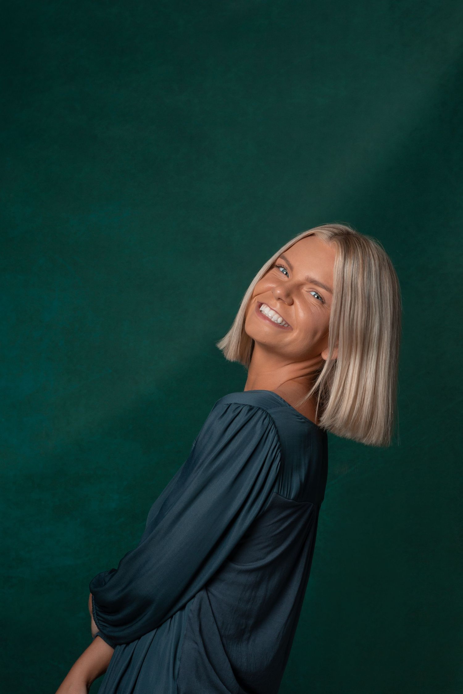 Portrait of a women dressed in blue on a blue backdrop.