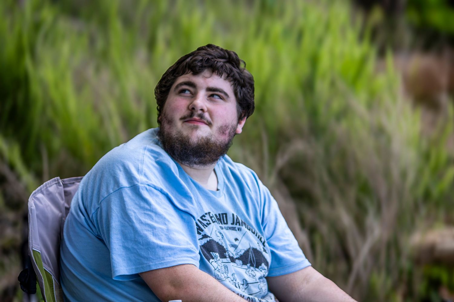Cinematic outdoor male portrait shot against a natural green landscape in Kentucky