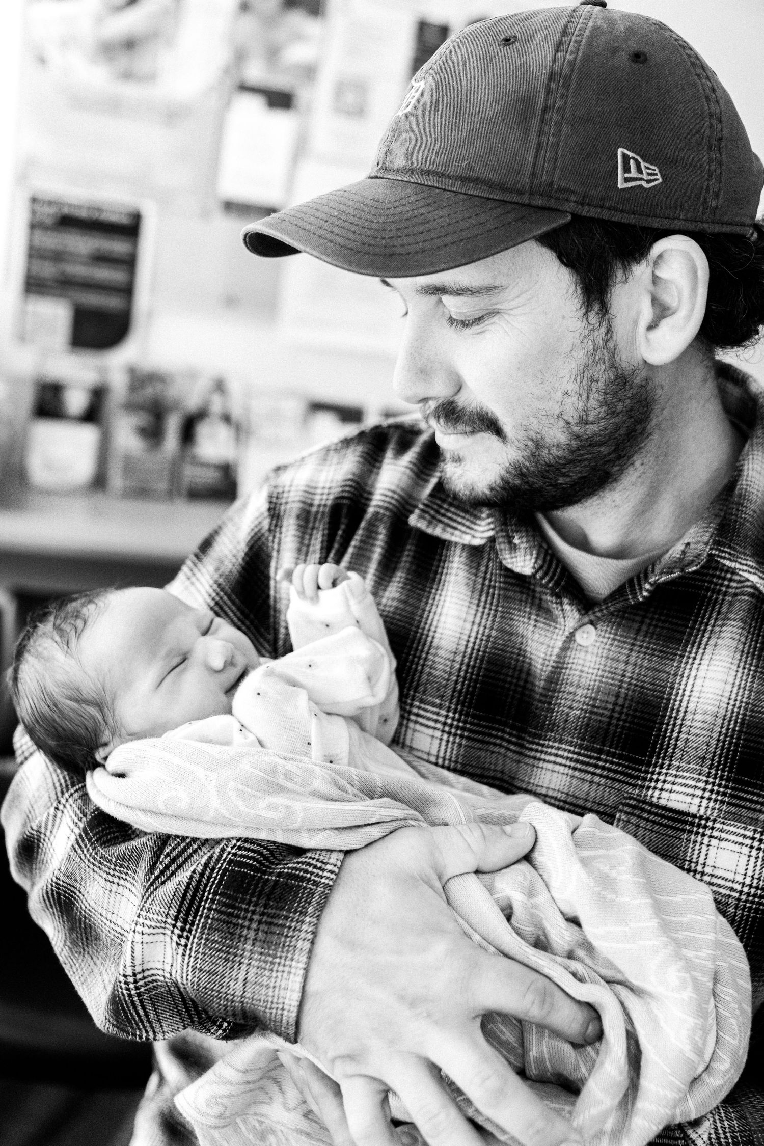 New dad tenderly holding a newborn baby. Nelson Newborn Photographer