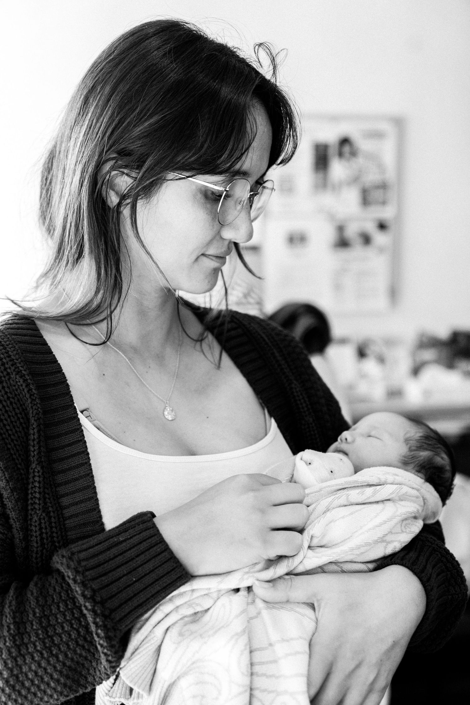 Woman tenderly holding and gazing at her newborn baby. Fresh 48 Photography captured by Nelson Newborn Photographer