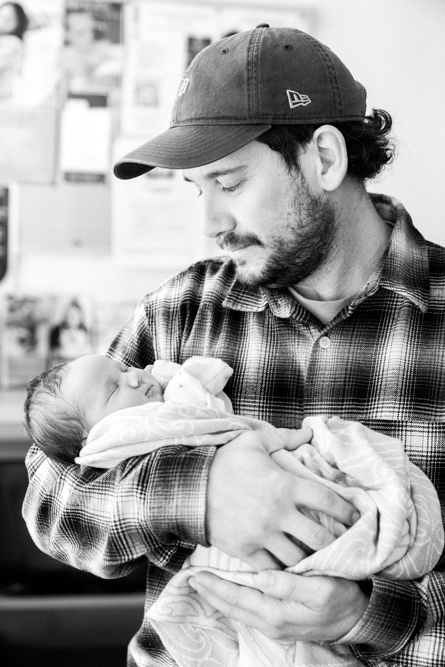 New dad tenderly holding a newborn baby. Nelson Newborn Photographer