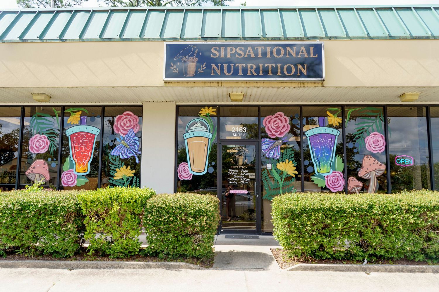 Exterior of Sipsational Nutrition store with colorful painted smoothie artwork on the windows.