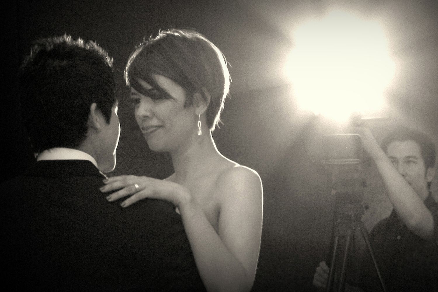Bride and groom share romantic first dance in black and white wedding photo.