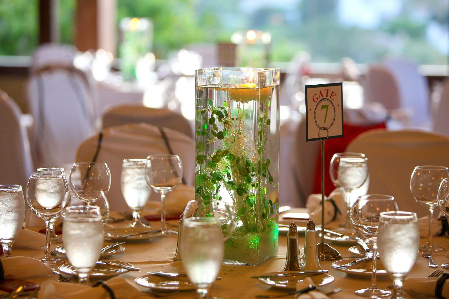Elegant wedding reception table with floral centerpiece, wine glasses, and table number seven card.