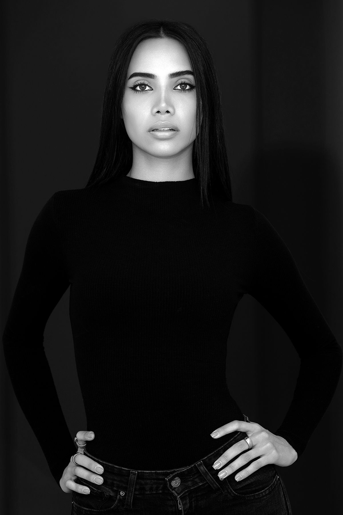Black and white portrait of a woman with straight hair in a black turtleneck top.