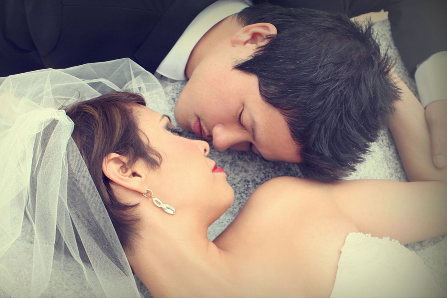Bride and groom sharing a tender romantic kiss on their wedding day.