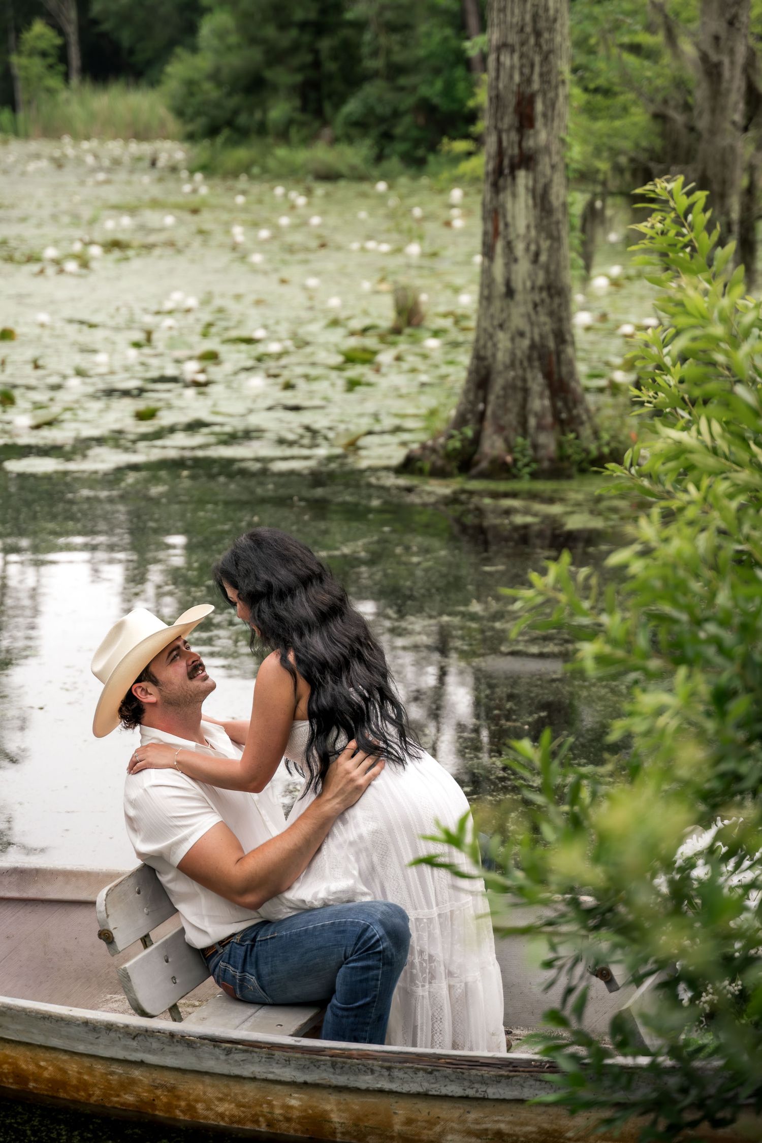 Cypress Gardens. Couple embracing romantically in a rowboat on a lily pad-covered swamp lake.
