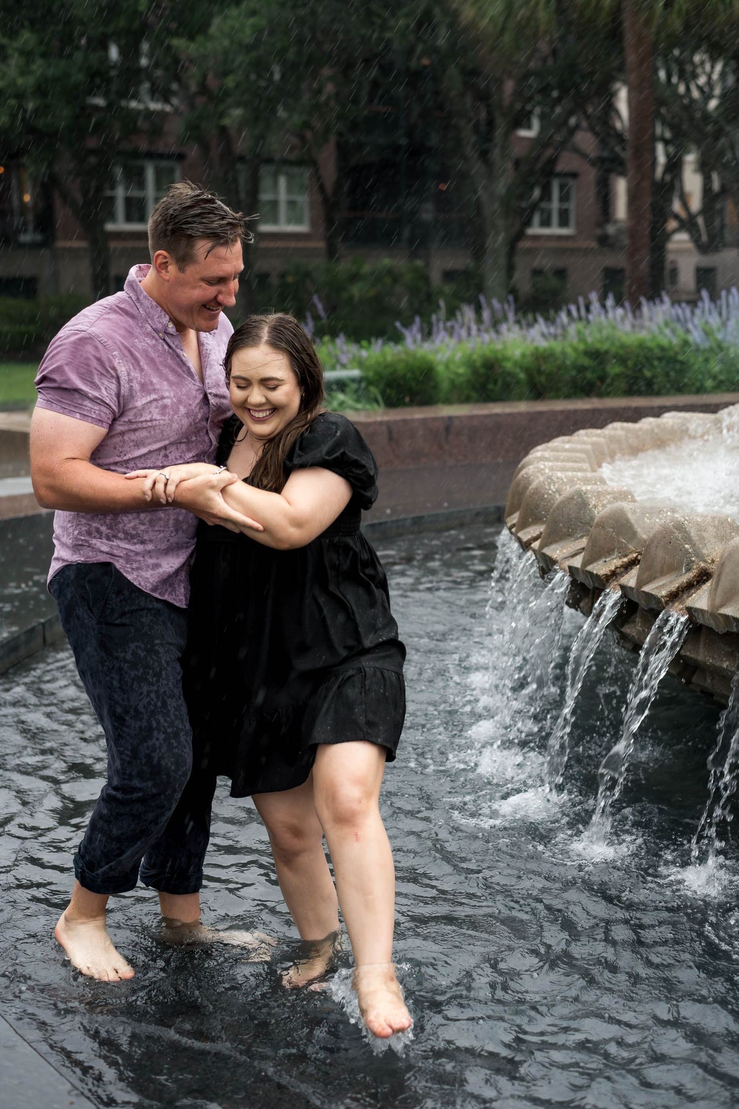 Pineapple Fountain. Couple laughing and splashing barefoot in a fountain during a rainy engagement photo session.