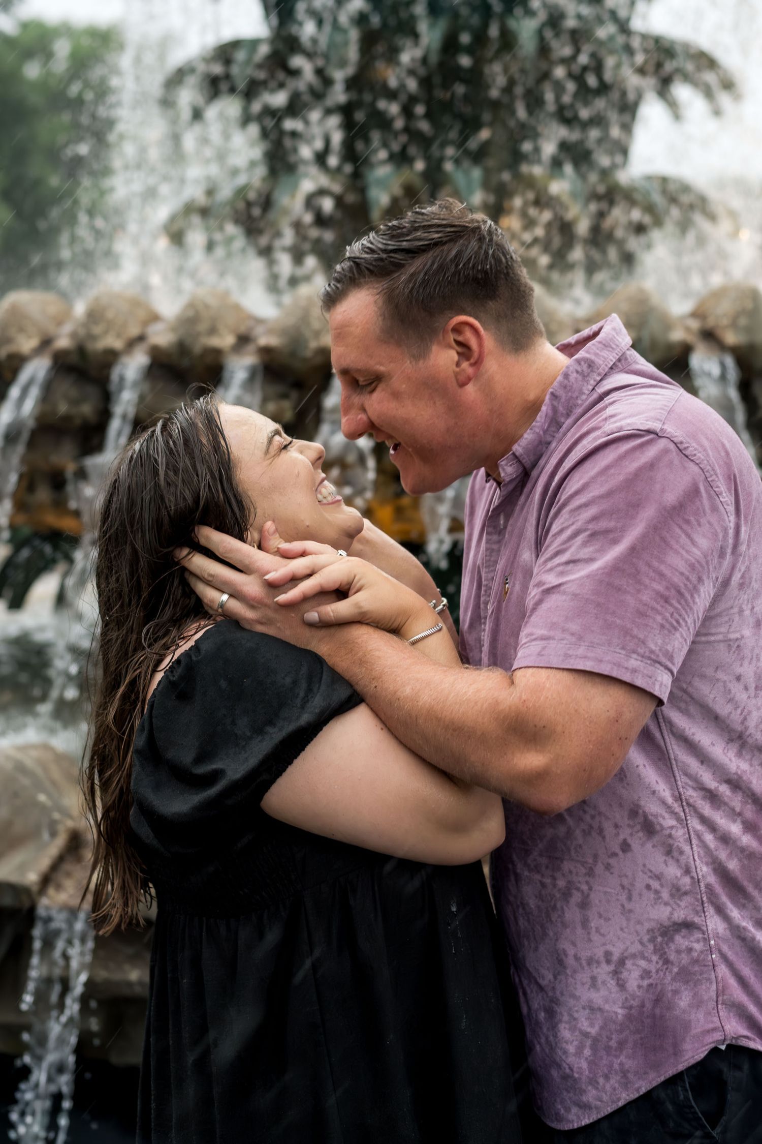Pineapple Fountain. Couple embracing and laughing together in front of a cascading fountain, soaking wet.