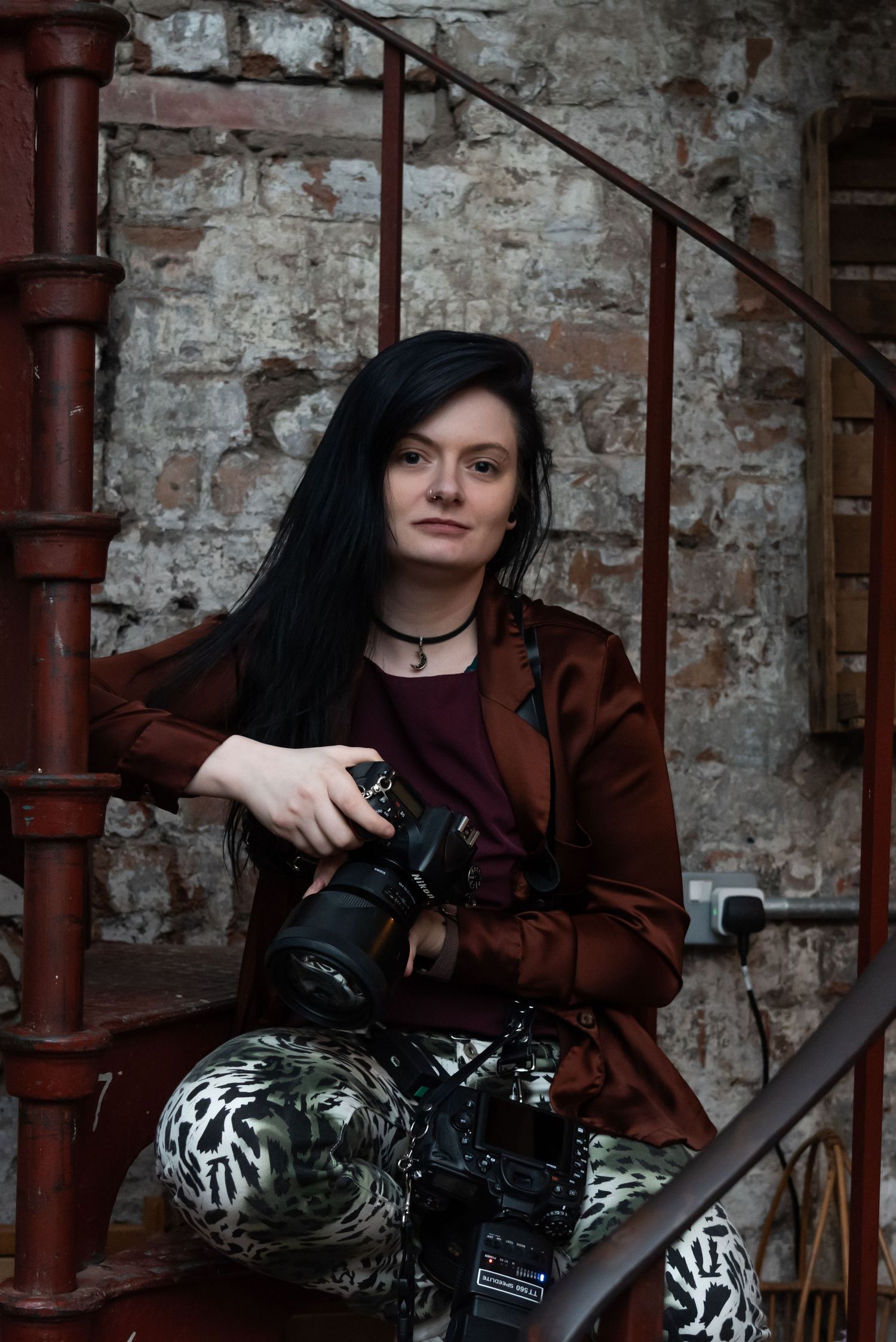 An artistic portrait in an industrial setting with exposed brick walls and metal pipes.