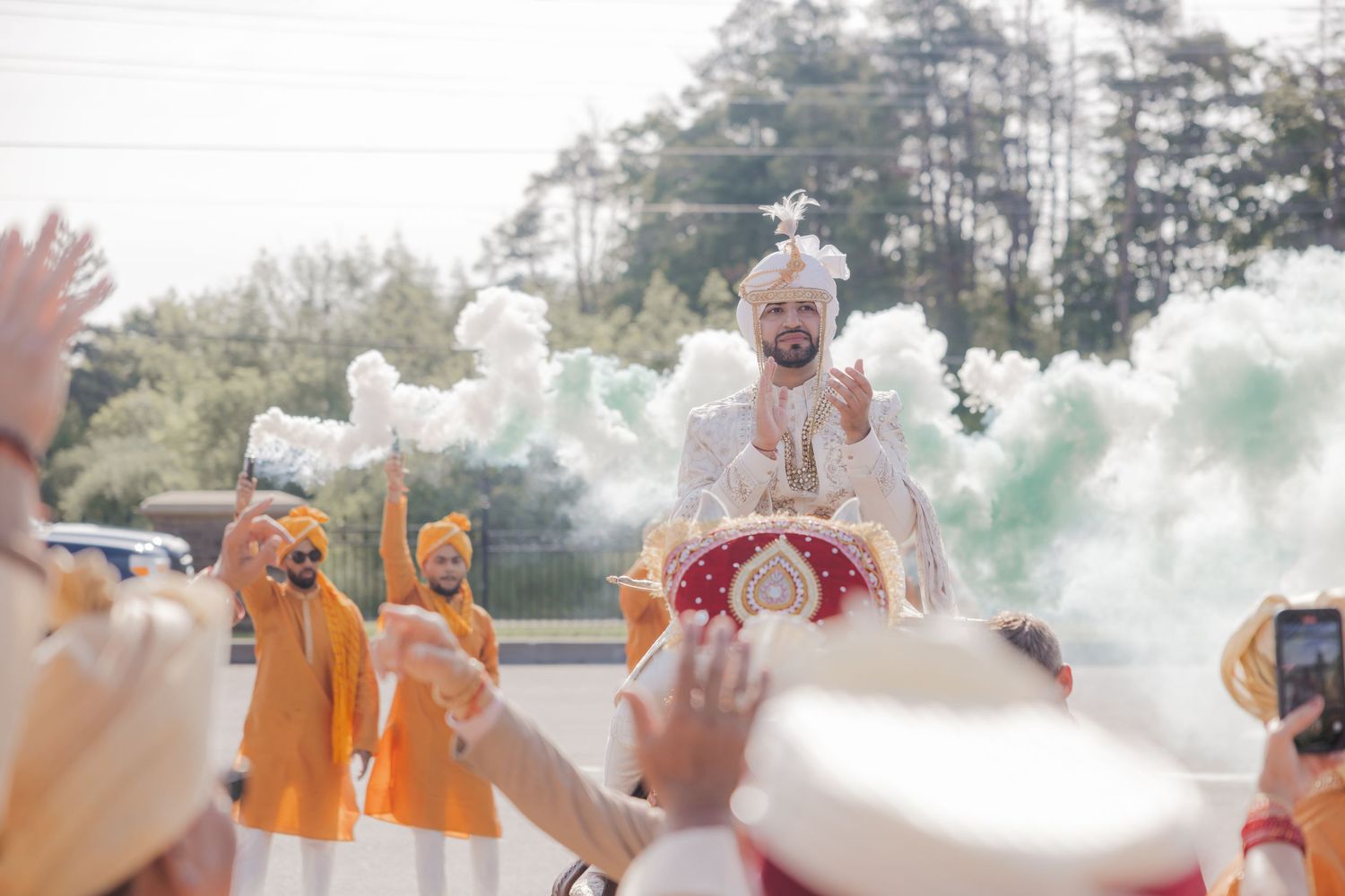 Hands throw colorful powder into the air during a festive celebration creating a vibrant cloud of colors.
