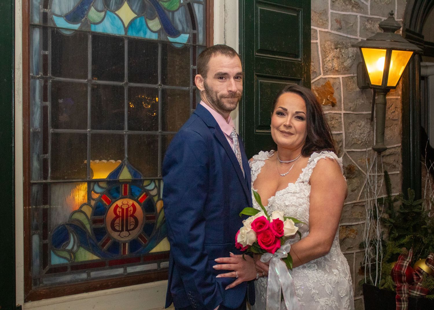 Two people celebrate outside a church at night with stained glass windows and warm lighting creating romantic atmosphere.