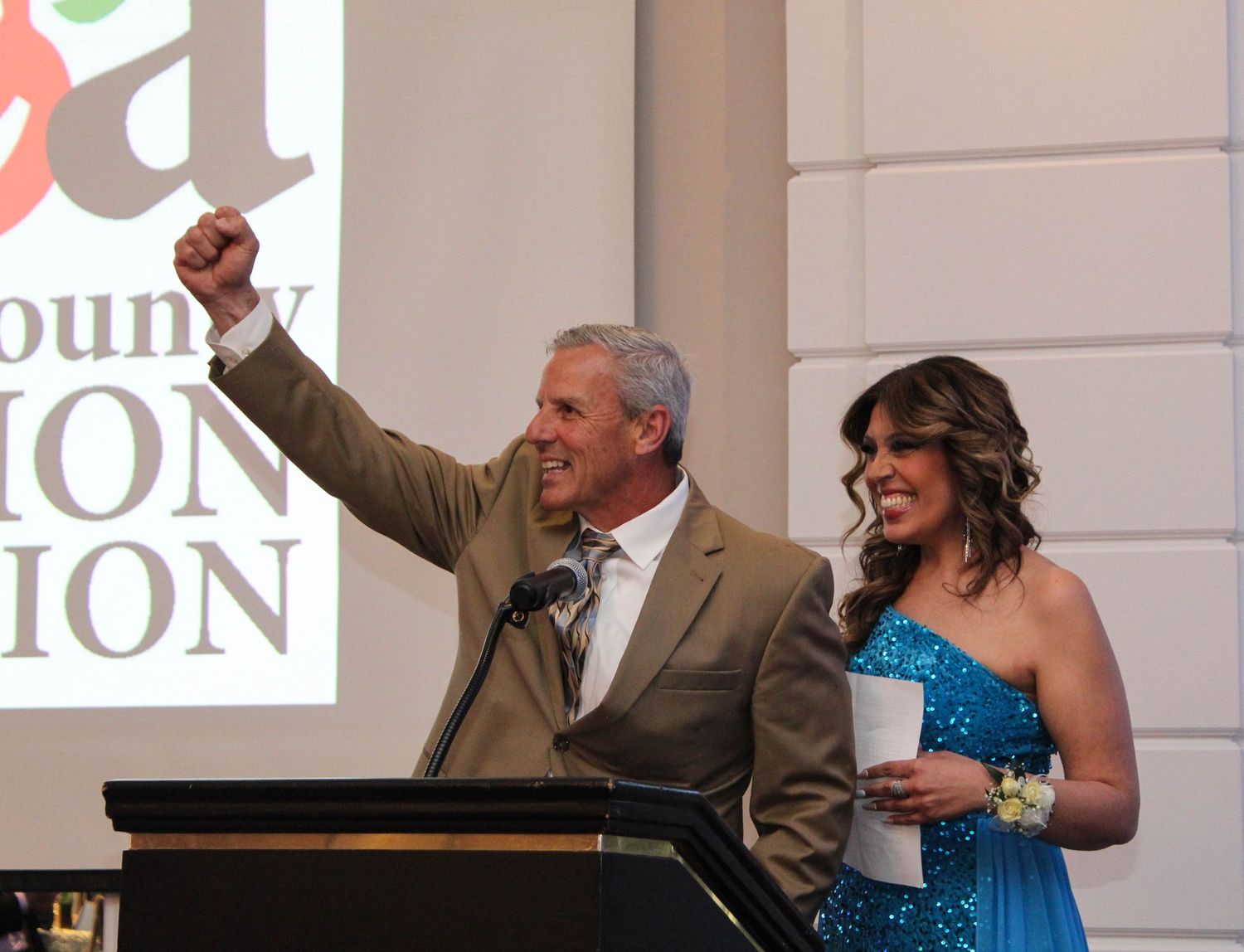 Speakers at a podium presenting during a formal event.