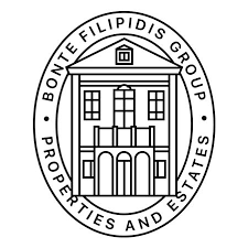 Circular emblem featuring line drawing of classical building facade with text around border.