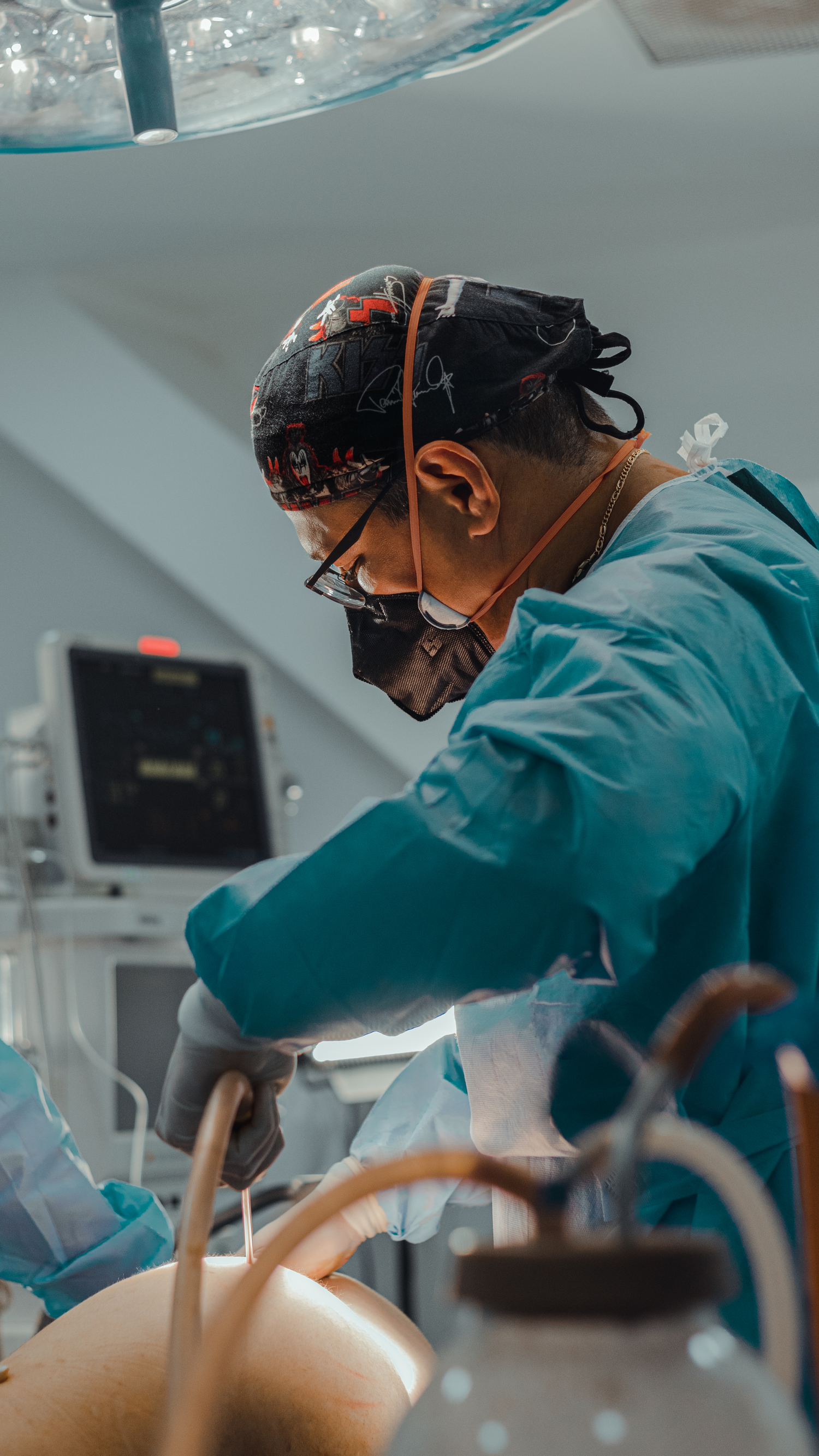 Healthcare professional in surgical attire focused during medical procedure.