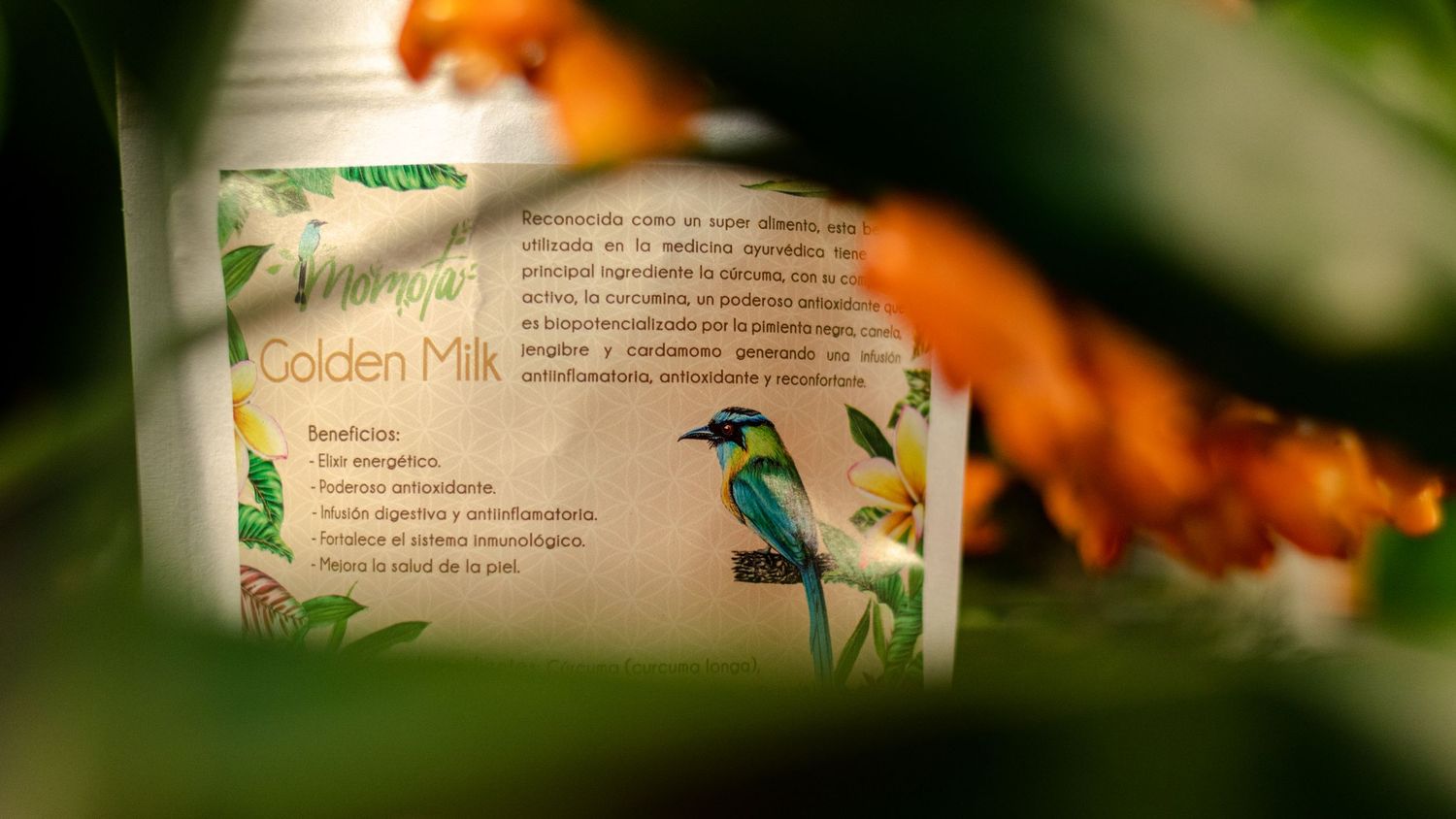 Product packaging with tropical bird illustration peeking through blurred foliage.