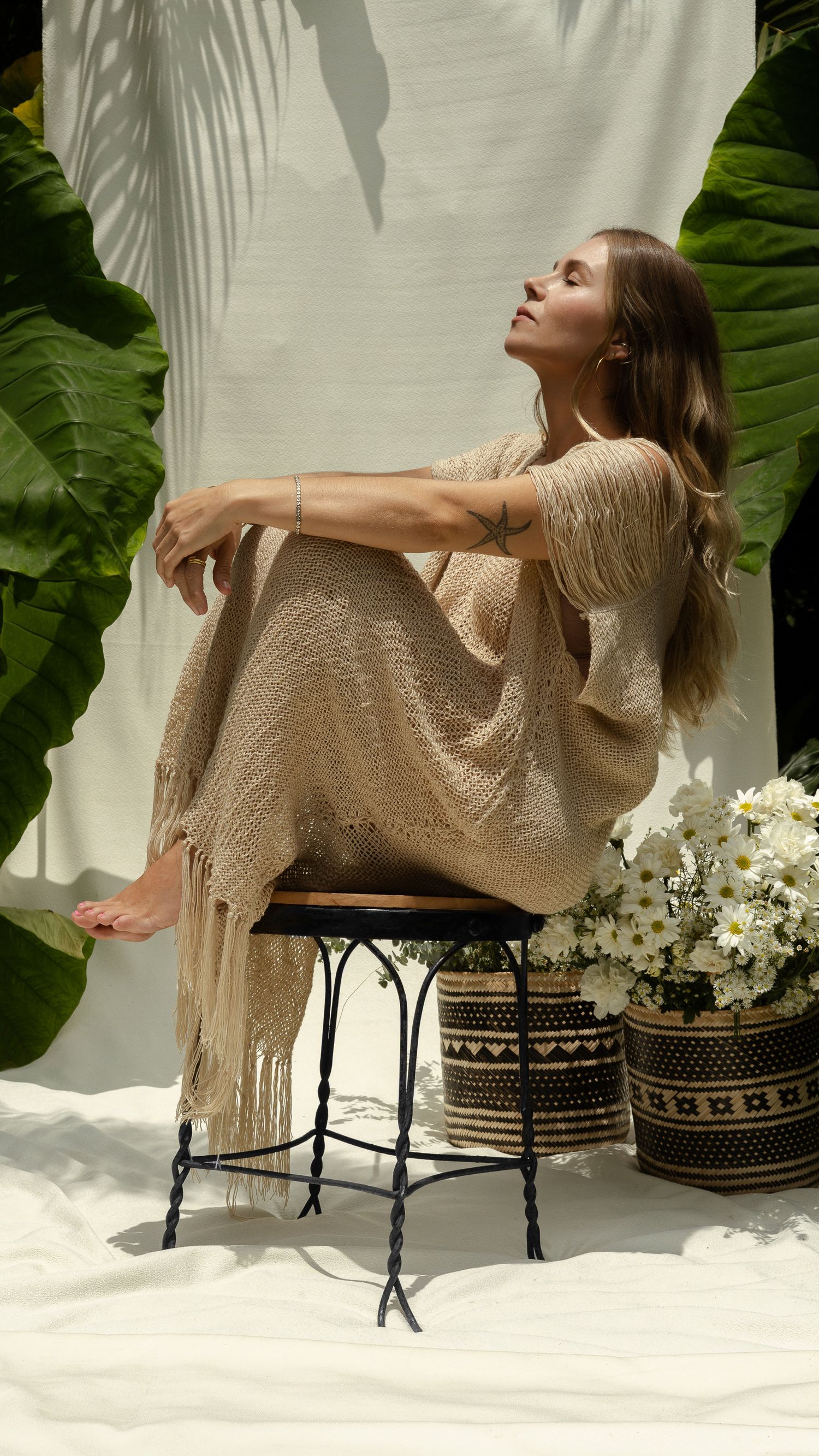 A serene scene with soft shadows and tropical leaves framing a tranquil outdoor setting.
