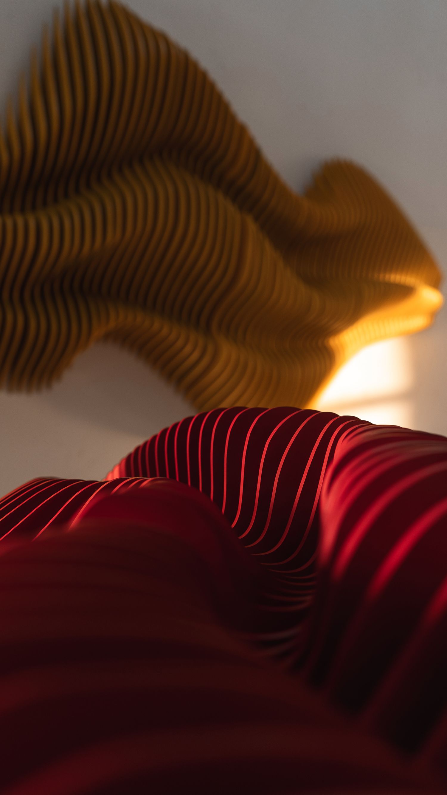 Abstract waves in red and gold colors with rippling texture effect.