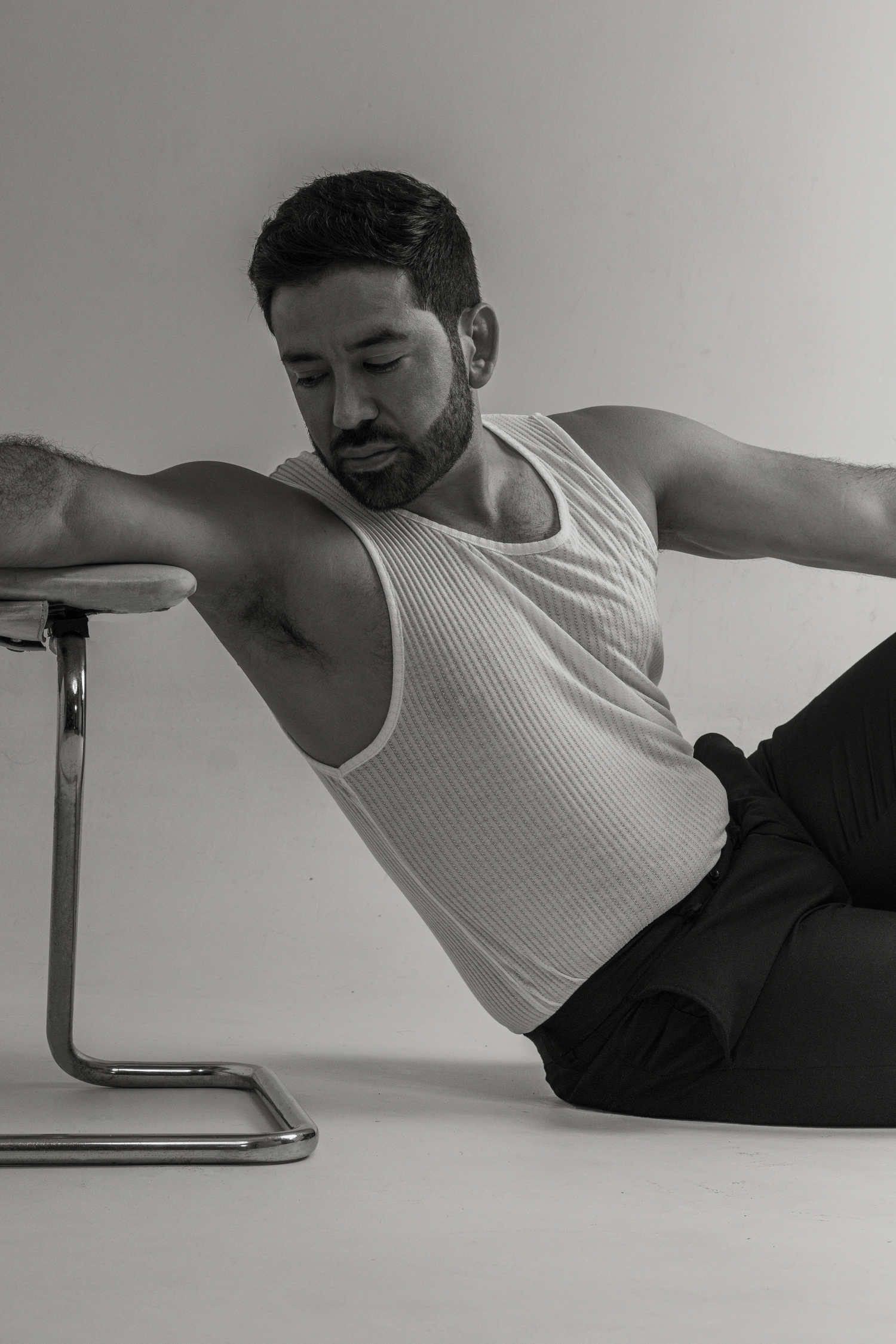 Athletic figure in white tank top demonstrating side plank exercise position.