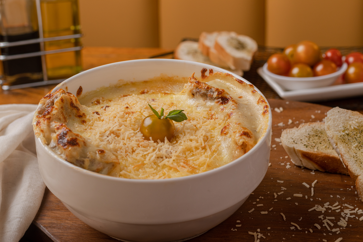 Creamy white baked dip in ceramic bowl with melted cheese and herbs.