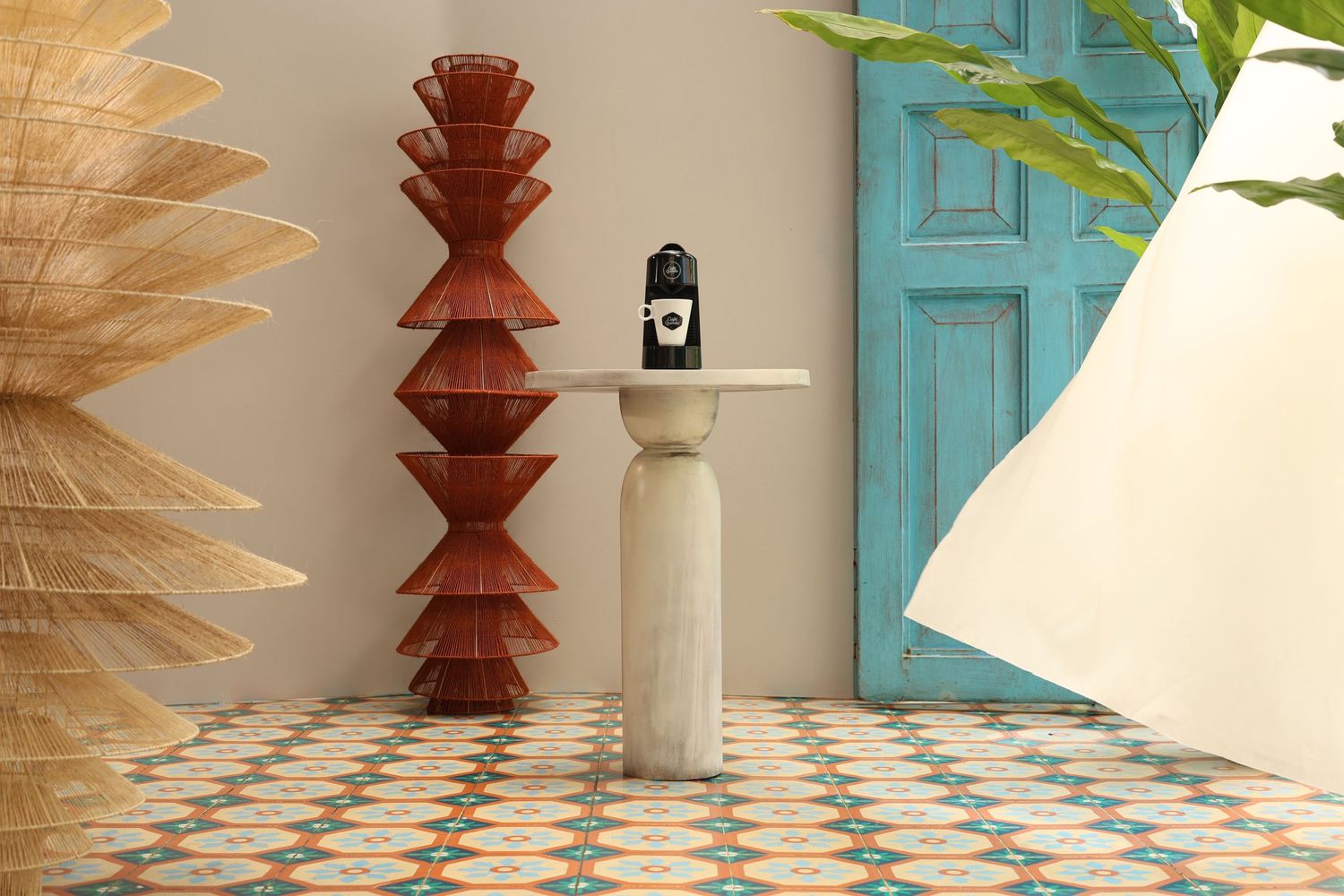 Modern interior design with turquoise door, geometric art, and patterned tile floor.