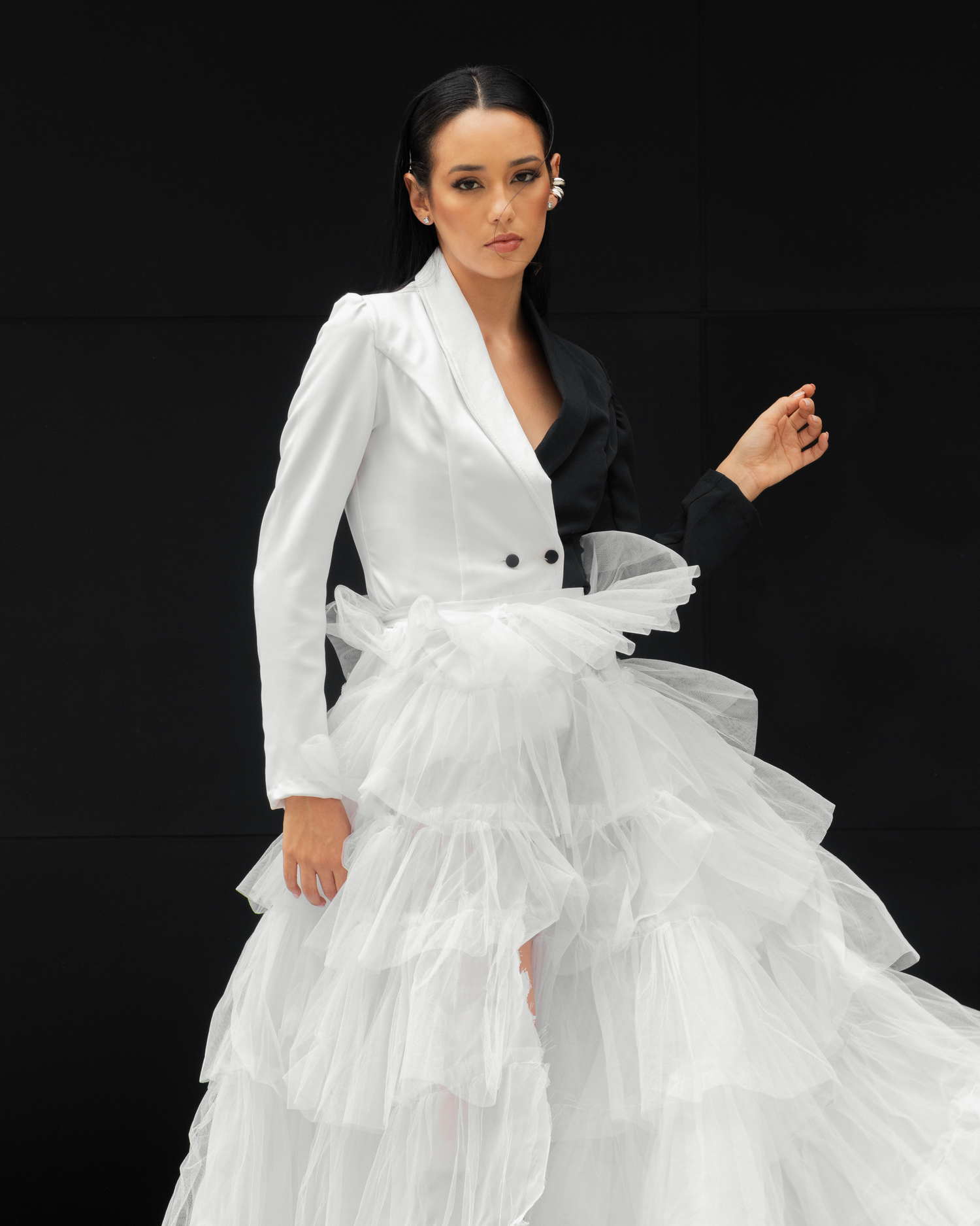 Avant-garde fashion photo featuring half white, half black blazer with tulle skirt.