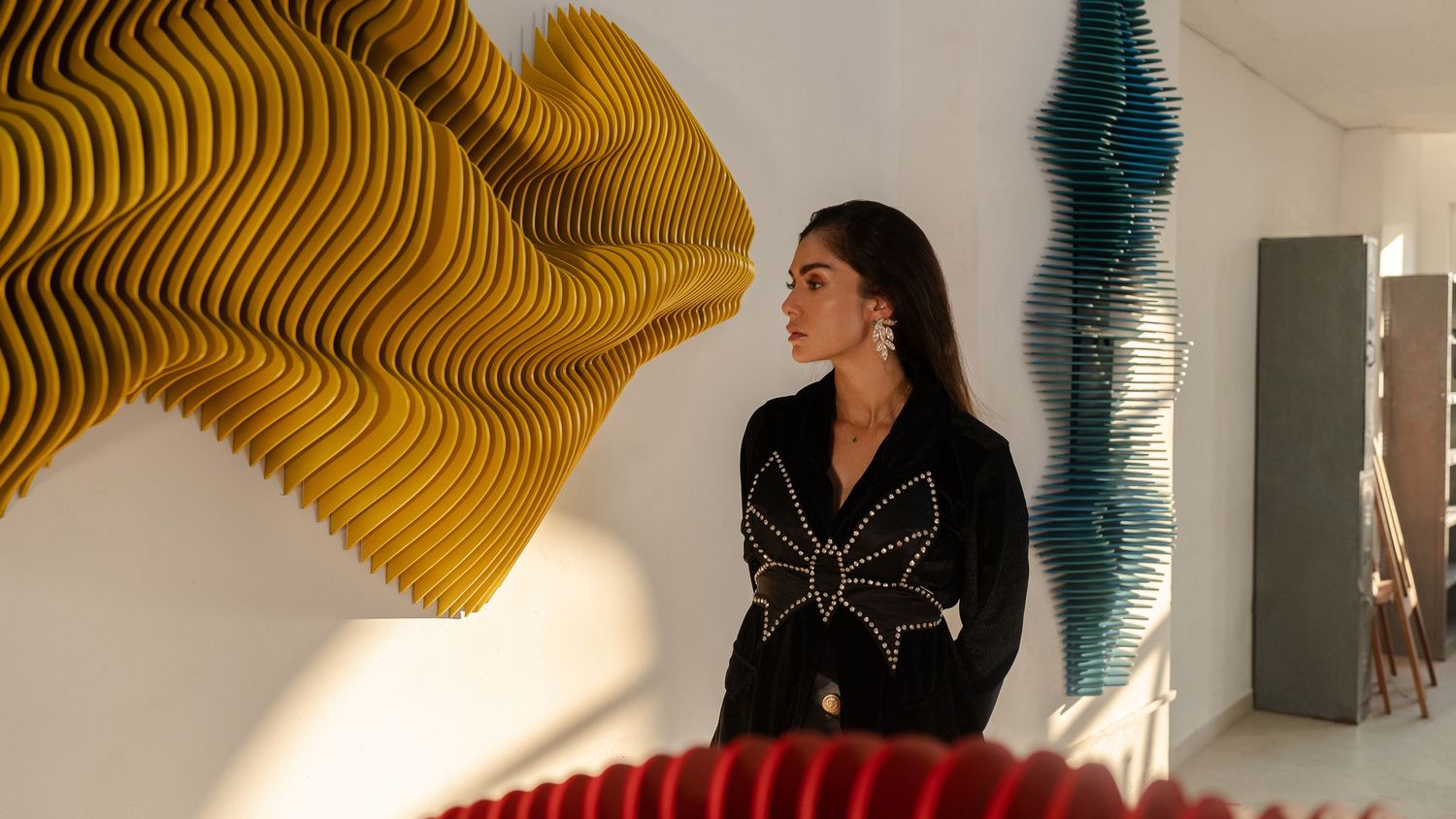 Interior scene with sculptural wave art installations in yellow and teal.
