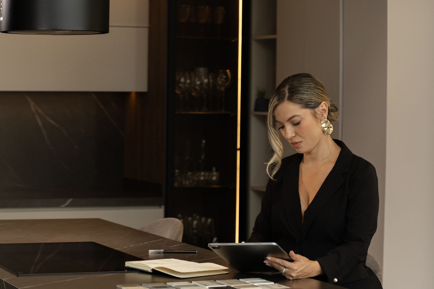 Elegant business person working at desk with digital tablet in modern office.