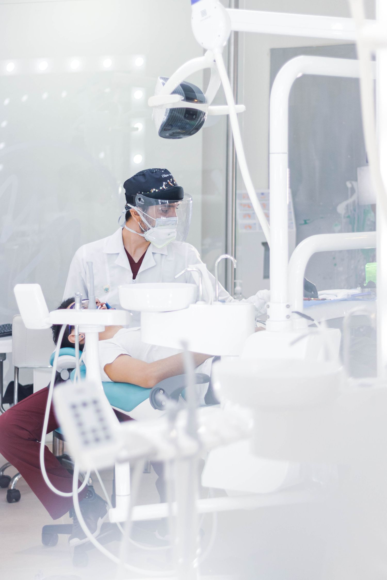 Dentist in protective equipment working in modern dental office.