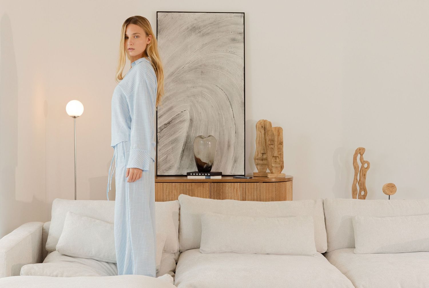 Light and airy bedroom interior with soft blue sleepwear and white bedding creating a peaceful atmosphere.